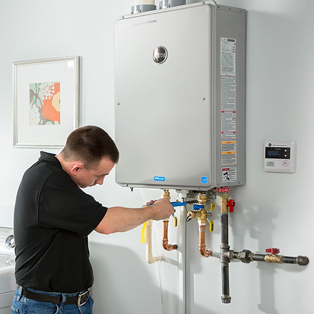 Tankless Water Heater Service in Scarborough - ME as a technician inspects wall-mounted heating equipment