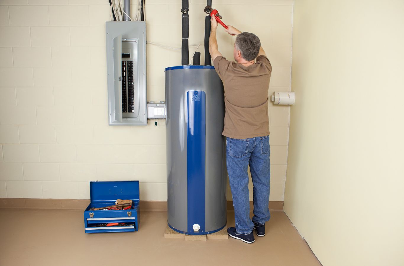 Technician fitting tank pipework, shown for Wanda’s Water Heaters in Wells, ME. Water Heater Installation Near Me.
