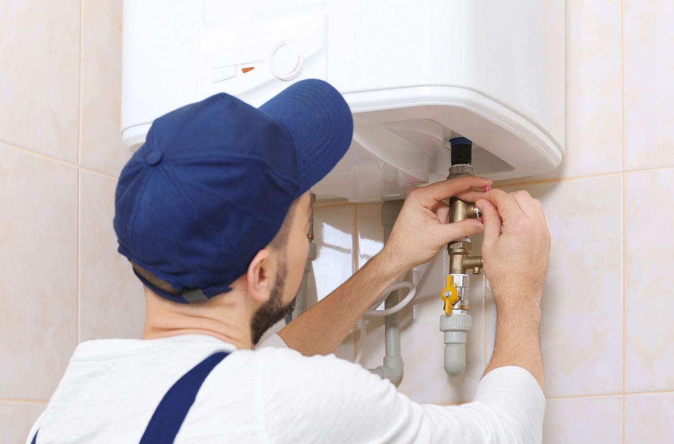 Technician at a tank connection, shown for Wanda’s Water Heaters in Portland, ME. Water Heater Installation Near Me.